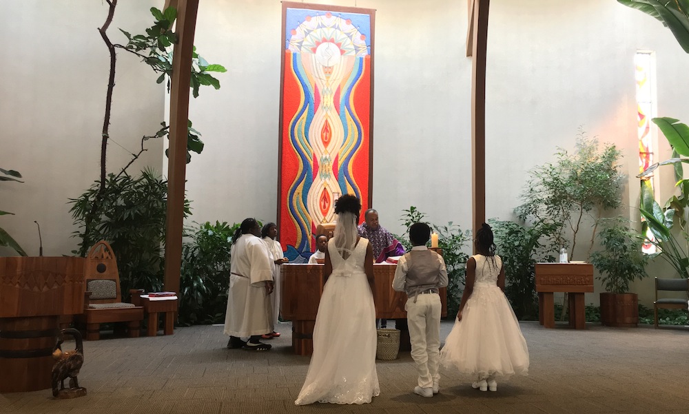 children dressed in white approaching Catholic Mass altar in preparation of first communion
