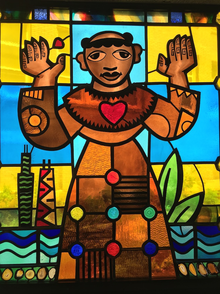 Colored stained glassed church window of saint Benedict the African with heart