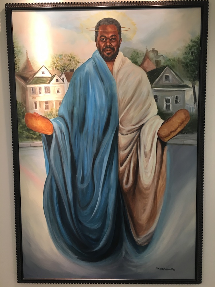 Saint Benedict the African picture frame holding loaves of bread.